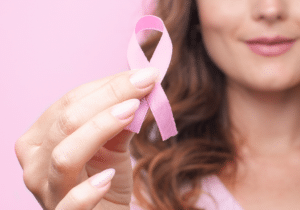 A woman holds a breast cancer ribbon