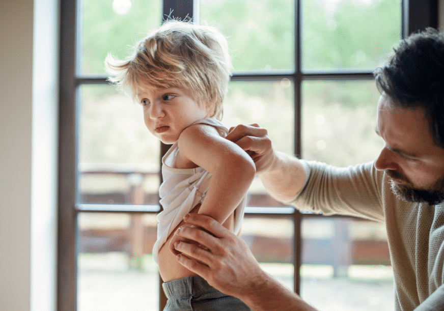 A man examines his son's back