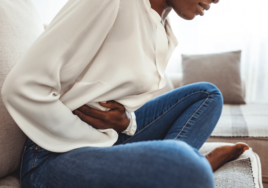 A woman is doubled over in stomach pain