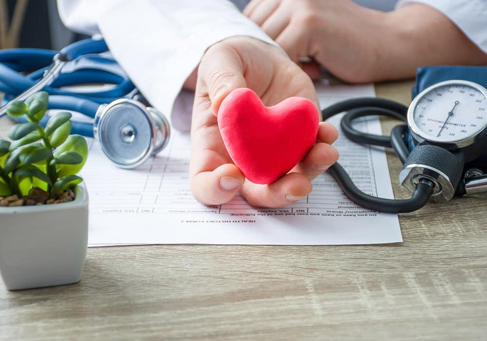 A doctor holds a heart shaped stethoscope