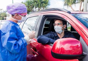 a man is tested for covid from his car