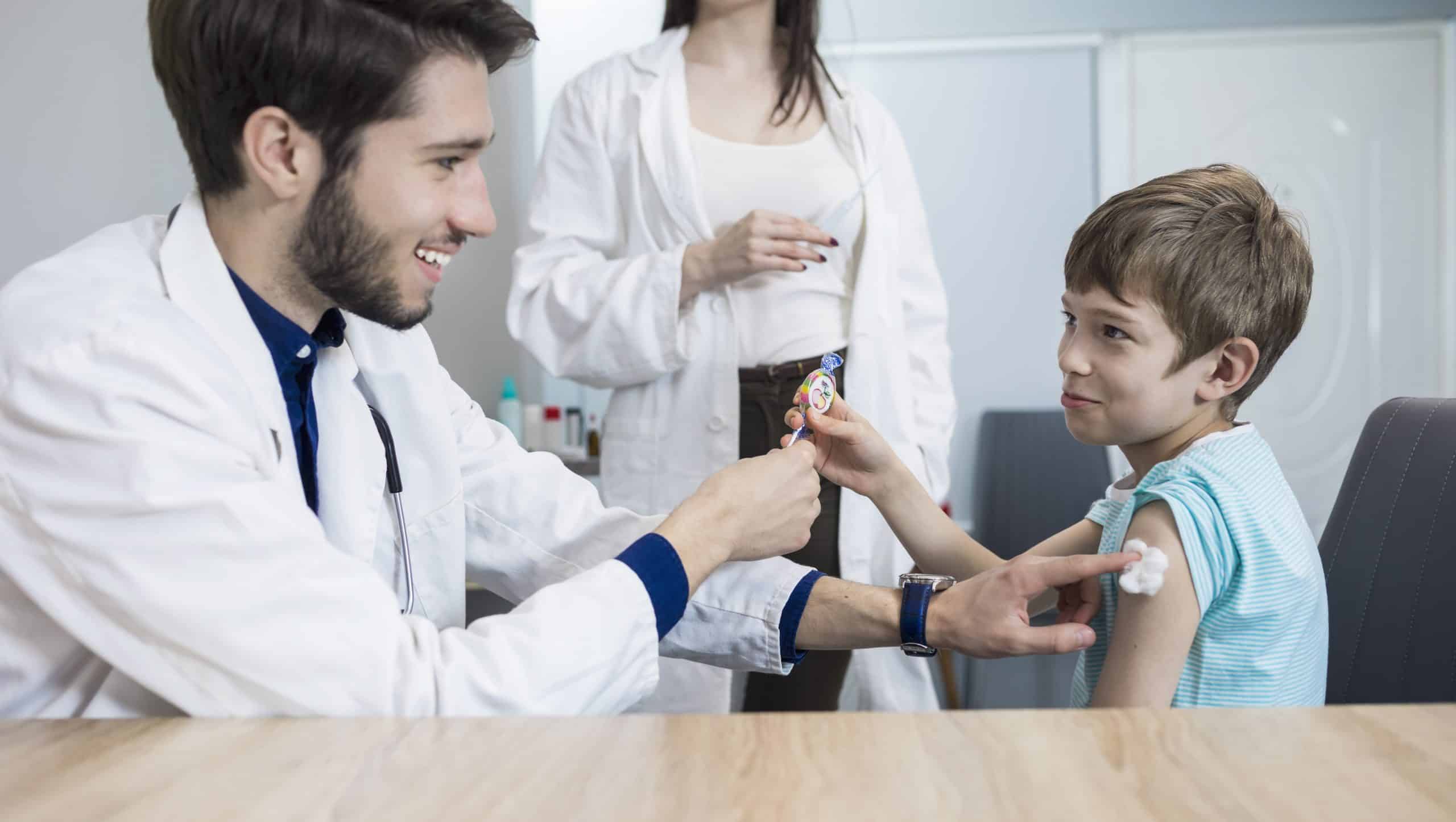 A doctor gives a boy a shot