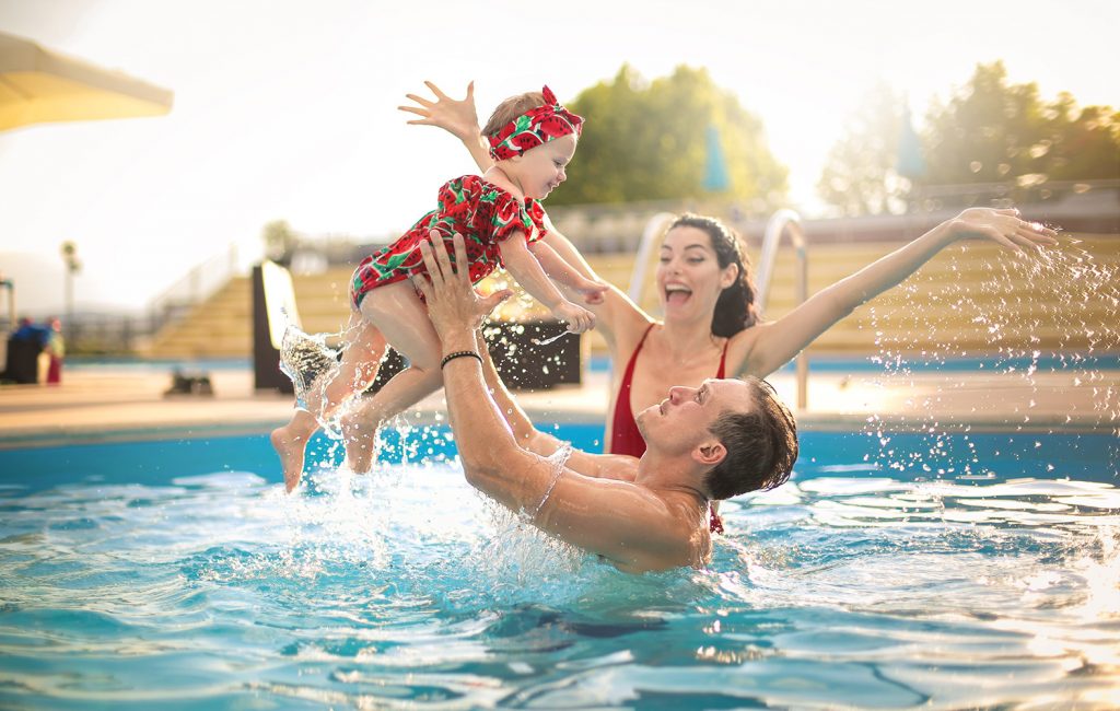 parents play with their child in a pool