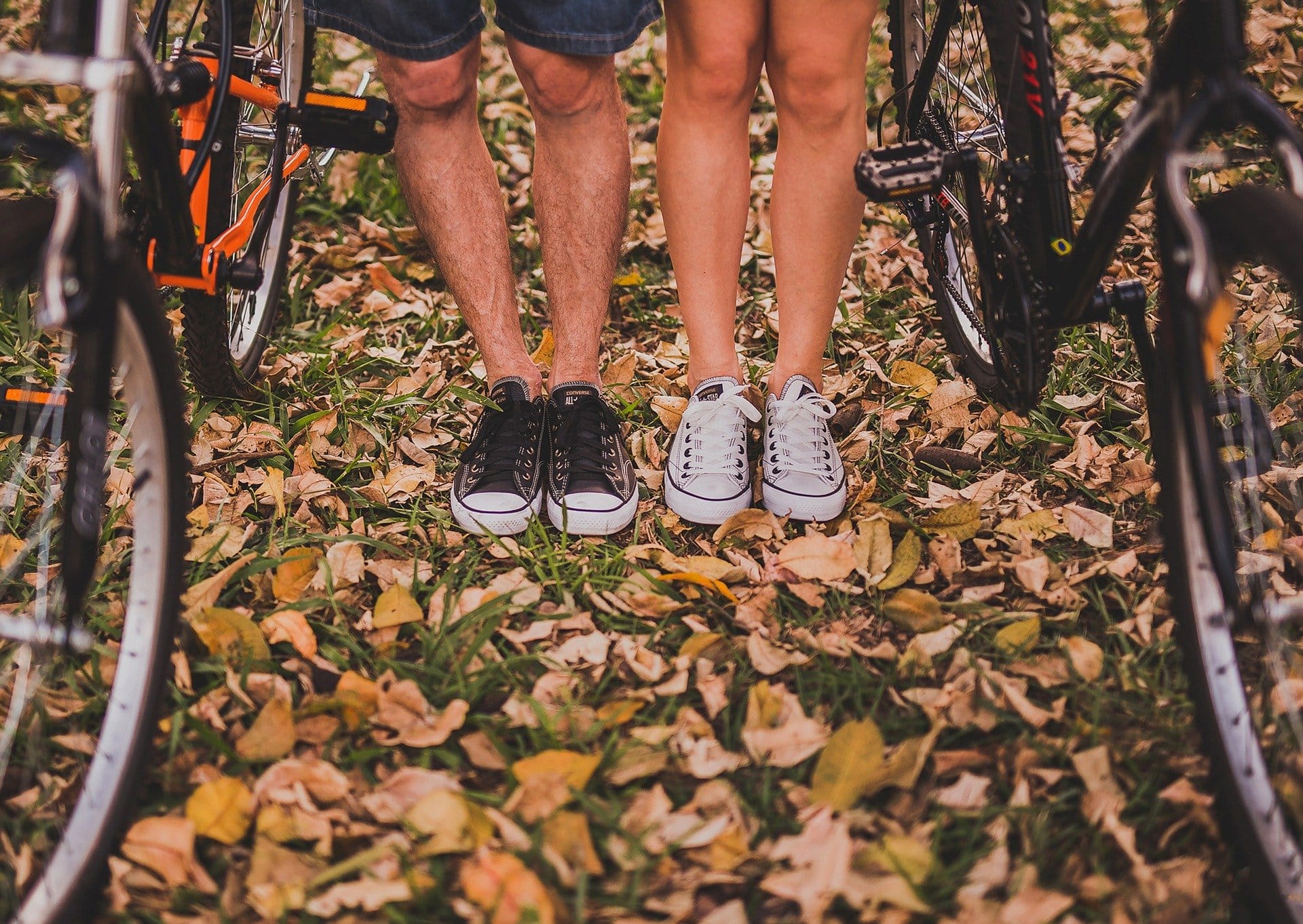 A couple stands between two bikes on a date night